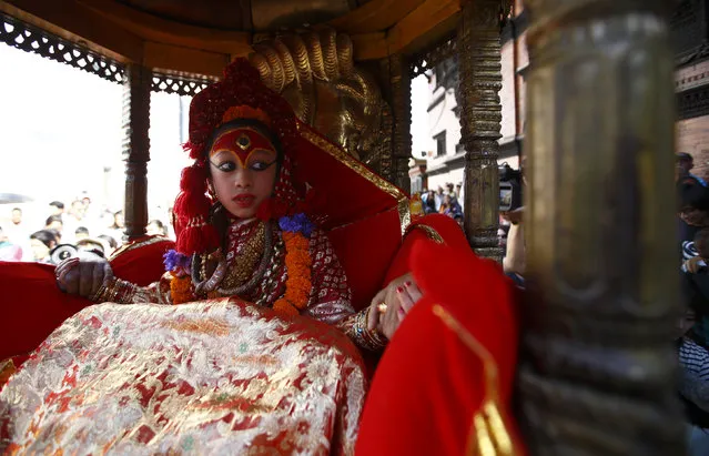 The Living Goddess Kumari on her chariot is brought to witness performances during the “Ghodejatra” horse race festival in Kathmandu March 30, 2014. The Nepal Army performed various horse related sports and races during the festival. (Photo by Navesh Chitrakar/Reuters)