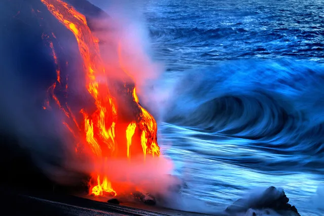 Two daredevil photographers have risked their lives to become the first people to capture the explosive moment fiery lava crashes into the sea – while in the water themselves. Fearless duo Nick Selway, 28, and pal CJ Kale, 35, brave baking hot 110F (43,3C) waters to snap the amazing images – standing just feet away from scalding heat and floating lava bombs. (Photo by Nick Selway/CJ Kale/Caters News Agency)