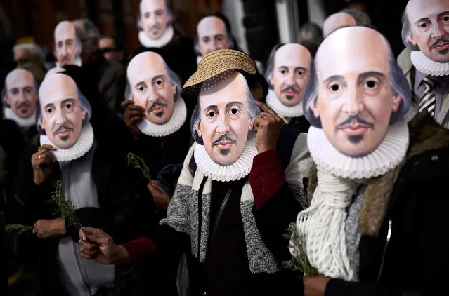 People hold up face masks with William Shakespeare's portrait during celebrations to mark the 400th anniversary of the playwright's death in the city of his birth, Stratford-Upon-Avon, Britain, April 23, 2016. (Photo by Dylan Martinez/Reuters)