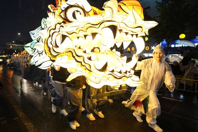Buddhists walk with a giant lantern in the share of a dragon during the Lotus Lantern Festival, ahead of the birthday of Buddha at Dongguk University in Seoul, South Korea, Saturday, May 11, 2024. (Photo by Ahn Young-joon/AP Photo)