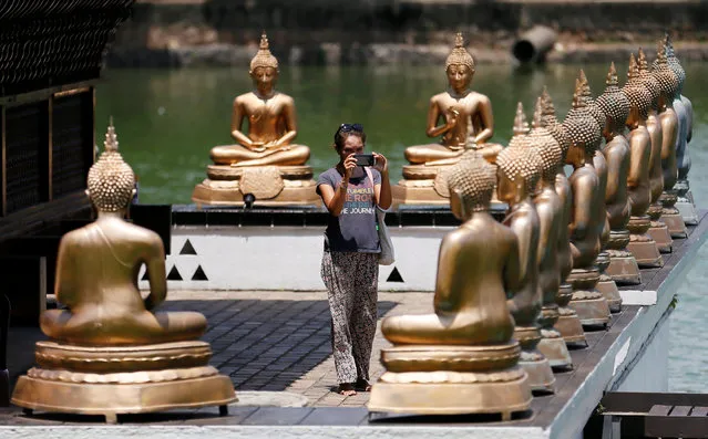 A tourist takes pictures of Buddha statues at a temple in Colombo, Sri Lanka May 4, 2016. (Photo by Dinuka Liyanawatte/Reuters)