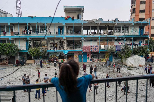 A Palestinian girl watches as others check a UN-school housing displaced people that was hit during Israeli bombardment in Nuseirat, in the central Gaza Strip, on June 6, 2024, amid the ongoing conflict between Israel and the Palestinian Hamas militant group. The Israeli military said on June 6 its fighter jets had struck a UN-run school used by Palestinian militants in central Gaza, with authorities in the Hamas-run territory reporting at least 27 dead. (Photo by Bashar Taleb/AFP Photo)