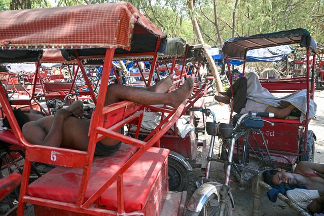 Rickshaw pullers rest on a hot summer day in New Delhi on June 18, 2024, amid heatwave. (Photo by Arun Sankar/AFP Photo)