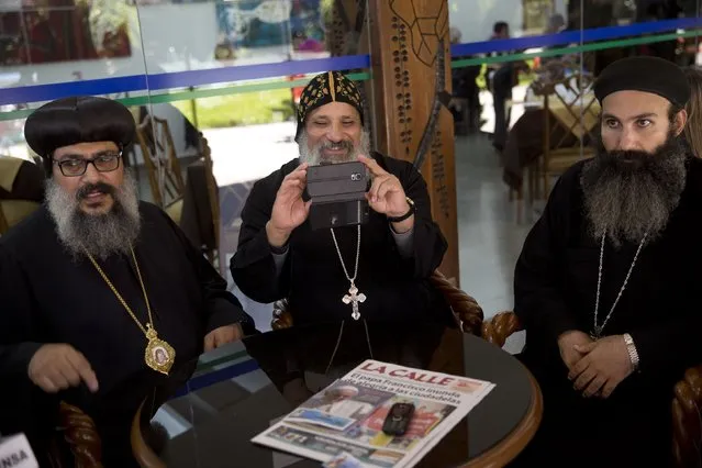 A member of the Orthodox Coptic church takes pictures with his cell phone after attending Mass celebrated by Pope Francis at Christ the Redeemer square in Santa Cruz, Bolivia, Thursday, July 9, 2015. Francis arrived in the Andean nation late Wednesday after three days in Ecuador. (Photo by Rodrigo Abd/AP Photo)
