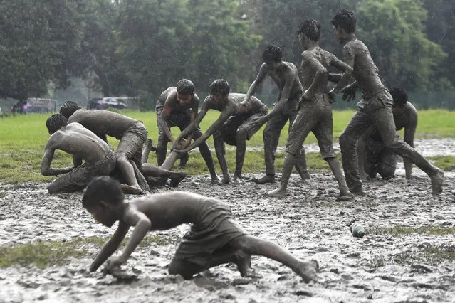 Children play a game of Kabaddi on water logged grounds in Kolkata on September 8, 2019. (Photo by Dibyangshu Sarkar/AFP Photo)
