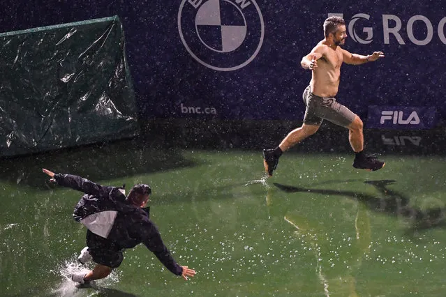 Security chase a spectator on centre court during a rain delay on Day Two of the National Bank Open presented by Rogers at IGA Stadium on August 10, 2021 in Montreal, Canada. (Photo by Minas Panagiotakis/Getty Images)