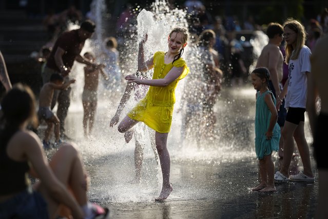 A youngster cools off in a fountain at VDNKh (The Exhibition of Achievements of National Economy) enjoying the warm weather, in Moscow, Russia,Sunday, June 30, 2024. Warm weather has settled in Moscow with a temperature of 31 Celsius, (87,8 Fahrenheit) and will increase in the coming days. (Photo by Alexander Zemlianichenko/AP Photo)