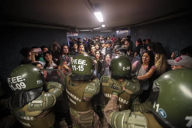 Chilean Police close the access to the Los Heroes metro station in the middle of a demonstration, in Santiago, Chile, 18 October 2019. The latest rise in the price of the Santiago de Chile Metro tickets has unleashed this week a wave of protests in several suburban stations. For the fifth consecutive day, this Friday there were incidents in 15 subway stations in the Chilean capital, where the police presence has increased with the passing days due to the intensity of the protests. (Photo by Alberto Pena/EPA/EFE)