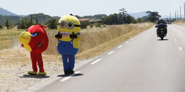 Two disguised spectators wait for the riders to pass during the sixteenth stage of the Tour de France cycling race over 201 kilometers (124.9 miles) with start in Bourg-de-Peage and finish in Gap, France, Monday, July 20, 2015. (Photo by Christophe Ena/AP Photo)