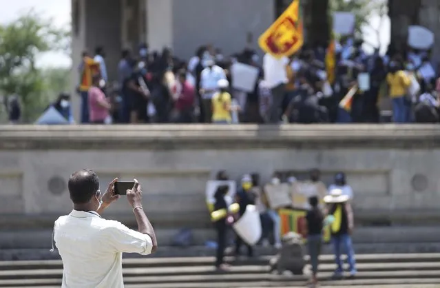 A plain clothed government security agent photographs Sri Lankans protesting demanding president Gotabaya Rajapaksa resign in Colombo, Sri Lanka, Monday, April 4, 2022. Sri Lanka’s president on Monday invited all political parties represented in Parliament to accept ministries after his Cabinet resigned amid public protests over the country’s worst economic crisis in memory that has caused shortages of food, fuel and medicines. (Photo by Eranga Jayawardena/AP Photo)