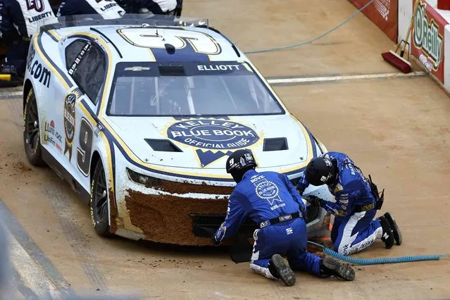 Crew members clean the front of the car of driver Chase Elliott (9) during a NASCAR Cup Series auto race, Sunday, April 17, 2022, in Bristol, Tenn. (Photo by Wade Payne/AP Photo)