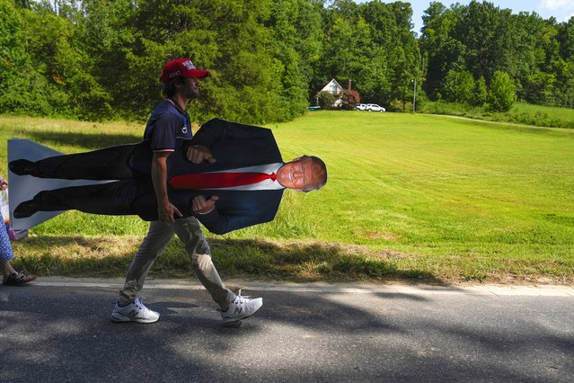 A supporters carries a stand-up of Republican presidential nominee former President Donald Trump after a campaign rally at North Carolina Aviation Museum, Wednesday, August 21, 2024, in Asheboro, N.C. (Photo by Julia Nikhinson/AP Photo)