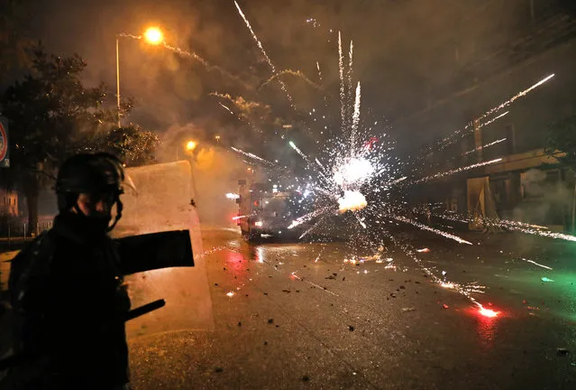 Supporters of Lebanon's Shiite Hezbollah and Amal groups hurl fireworks at security forces early on December 17, 2019 in central Beirut. Lebanon's president yesterday postponed consultation to select a new prime minister after weeks of largely peaceful street protests descended into weekend violence. (Photo by Anwar Amro/AFP Photo)