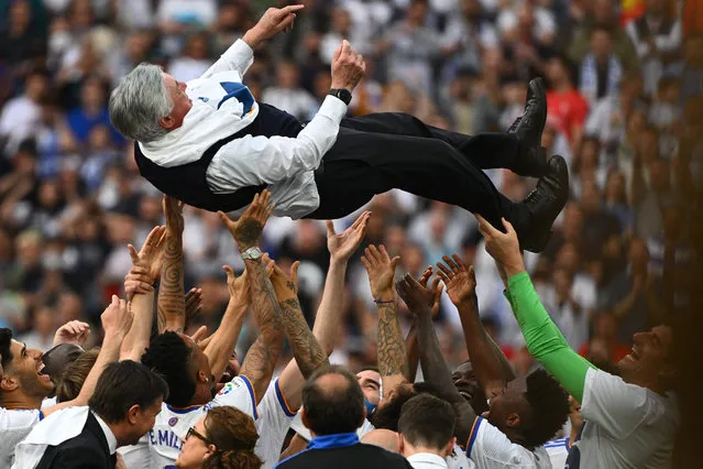 Real Madrid's players carry Real Madrid's Italian coach Carlo Ancelotti at the end of the Spanish League football match between Real Madrid CF and RCD Espanyol at the Santiago Bernabeu stadium in Madrid on April 30, 2022. Real Madrid secured a 35th La Liga title with four games to spare after a 4-0 home win over Espanyol that included two goals from Rodrygo. Needing just one point to clinch the trophy, Madrid struck twice through the Brazilian in the first half at the Santiago Bernabeu before further goals from Marco Asensio and Karim Benzema. (Photo by Gabriel Bouys/AFP Photo)