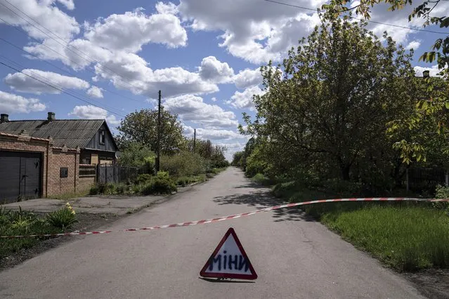 A sign that reads “Mines” placed on a road where unexploded devices were found after shelling of Russian forces in Maksymilyanivka, Ukraine, Tuesday, May 10, 2022. (Photo by Evgeniy Maloletka/AP Photo)