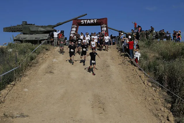 Participant start the Mud Day athletic event at El Goloso Military base on the outskirts of Madrid, Spain, Saturday, June 11, 2016. (Photo by Paul White/AP Photo)