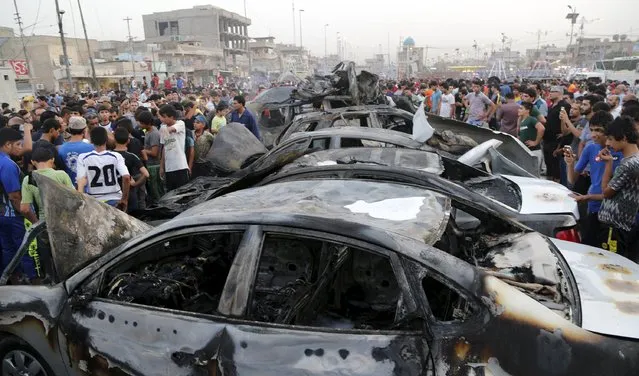 People look at damage at the site of a car bomb attack in Baghdad's Sadr City August 5, 2015. At least 10 people were killed and 22 others wounded in two car bomb attacks on Wednesday that targeted predominately Shi'ite neighborhoods in Baghdad, police and medical sources said. (Photo by Wissm al-Okili/Reuters)