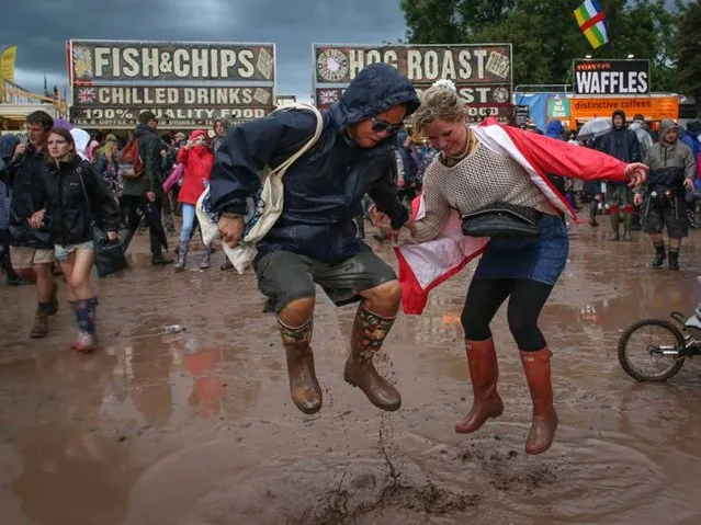 Festival goers jump in mud at Worthy Farm in Pilton during the 2014 Glastonbury Festival on June 27, 2014 in Glastonbury, England. (Photo by Matt Cardy/Getty Images)