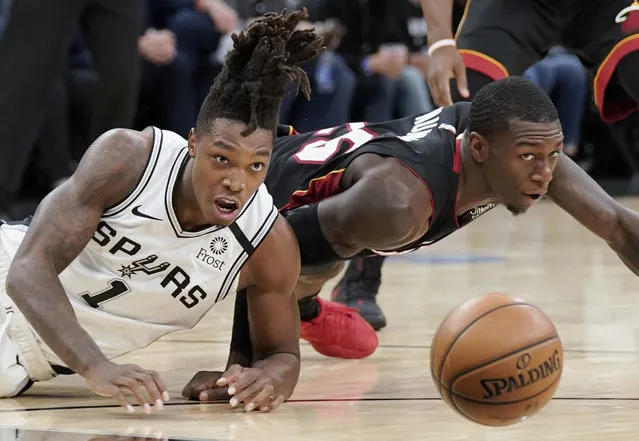 San Antonio Spurs' Lonnie Walker IV (1) and Miami Heat's Kendrick Nunn fall as they chase the ball during the first half of an NBA basketball game, Sunday, January 19, 2020, in San Antonio. (Photo by Darren Abate/AP Photo)