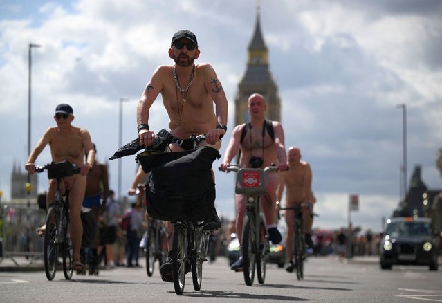 Cyclists take part in the World Naked Bike Ride in Westminster bridge, central London, on June 11, 2022. Participants ride naked on various routes across London to protest against the global dependency on oil and celebrate body freedom. (Photo by Daniel Leal/AFP Photo)