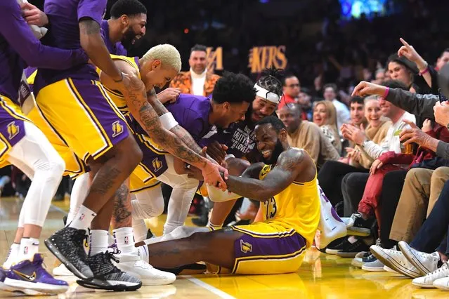 Los Angeles Lakers forward LeBron James I swarmed by teammates after making several 3-point shots in a row during the second half of the team's NBA basketball game against the San Antonio Spurs on Tuesday, February 4, 2020, in Los Angeles. (Photo by Mark J. Terrill/AP Photo)