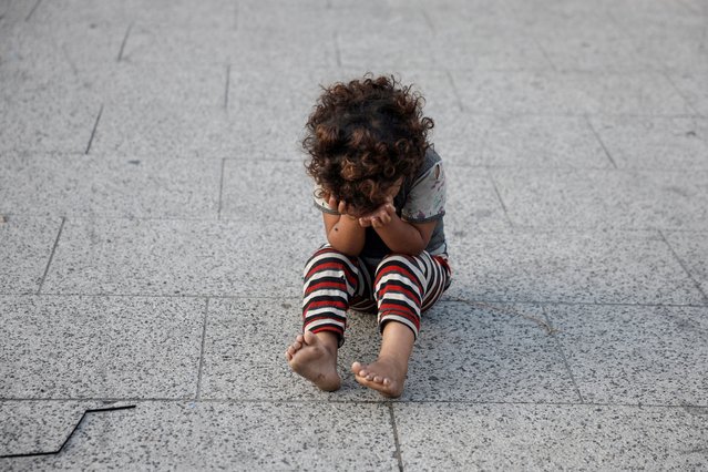 A displaced child sits on a pavement in the centre of the city amid the ongoing hostilities between Hezbollah and Israel, in Beirut, Lebanon on October 8, 2024. (Photo by Louisa Gouliamaki/Reuters)