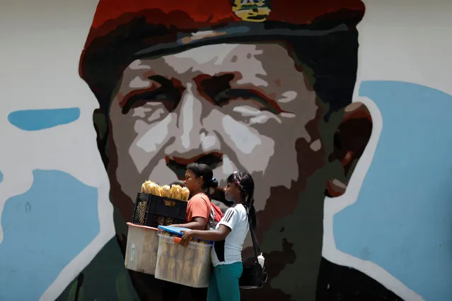 Women walk past a portrait of Venezuela's late President Hugo Chavez in Caracas, Venezuela August 7, 2017. (Photo by Ueslei Marcelino/Reuters)