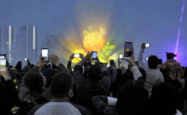 People use their phones to film during a ceremony celebrating Noruz (Nowruz), the Persian New Year, at the Iran Mall shopping centre in Iran's capital Tehran, on March 20, 2022. (Photo by AFP Photo/Stringer)