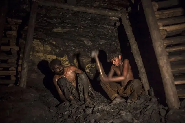 Samiullah (R), who says he is 14-years-old, breaks coal inside a mine in Choa Saidan Shah, Punjab province, April 29, 2014. (Photo by Sara Farid/Reuters)