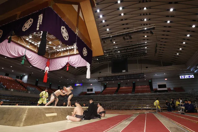 Sumo wrestlers fight on the ring as spectators' seats are empty during the Spring Grand Sumo Tournament in Osaka, western Japan, Sunday, March 8, 2020. The 15-day sumo tournament started on Sunday with no spectators, affected by fears of the new coronavirus outbreak. (Photo by Kyodo News via AP Photo)