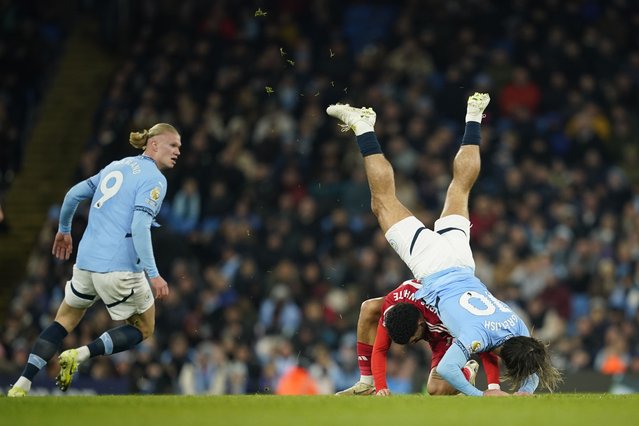 Nottingham Forest's Morgan Gibbs-White, centre, challenges for the ball with Manchester City's Jack Grealish, right, and Erling Haaland, left, during the English Premier League soccer match between Manchester City and Nottingham Forest at the Etihad Stadium in Manchester, Wednesday, December 4, 2024. (Photo by Dave Thompson/AP Photo)