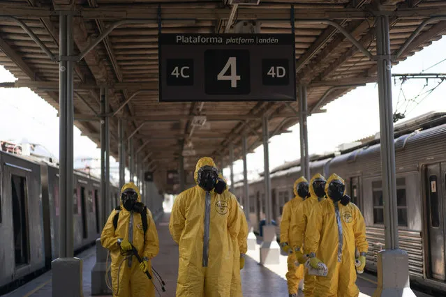 Soldiers stand in formation before disinfecting wagons for the new coronavirus at the central train station in Rio de Janeiro, Brazil, where trains connect cities within the state, Thursday, March 26, 2020. (Photo by Leo Correa/AP Photo)