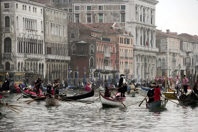 Boats with people wearing costumes sail on the “Canal Grande” during a boat parade during the Carnival February 19, 2006 in Venice, Italy. (Photo by Marco Di Lauro)
