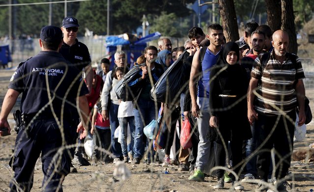 Migrants enter Macedonia near Gevgelija after crossing the border with Greece, September 1, 2015. Migrants are trekking from the southern Macedonian border near Gevgelija to the northern border with Serbia on their way to Western Europe. Trains carrying hundreds of migrants started arriving in Vienna on Monday after Austrian authorities appeared to give up trying to apply European Union rules by filtering out refugees who had already claimed asylum in Hungary. (Photo by Ognen Teofilovski/Reuters)