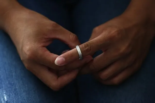 Liu, whose husband Li Zhijin was onboard Malaysia Airlines Flight MH370 which disappeared on March 8, 2014, tries her husband's ring on her finger as she shows it during an interview with Reuters in Beijing July 22, 2014. Liu said she argued with her husband in their last phone call before the incident.  She could not have realised that this would be their last conversation and now that is her greatest regret. (Photo by Kim Kyung-Hoon/Reuters)