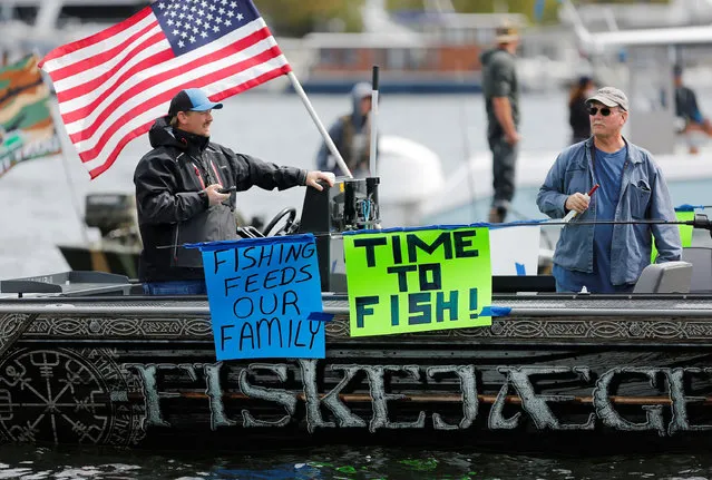 Two men hang signs off their boat as they gather with others on Lake Union to protest against the recreational fishing ban in Washington State, in place until at least May 4 due to the coronavirus disease (COVID-19) outbreak, in Seattle, Washington, U.S. April 26, 2020. (Photo by Lindsey Wasson/Reuters)