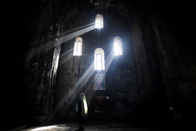 A woman prays in the Sts. Paul and Peter church at the 9th century Tatev monastery of the Armenian Apostolic Church some 270 km of Yerevan on October 8, 2017. (Photo by Kirill Kudryavtsev/AFP Photo)