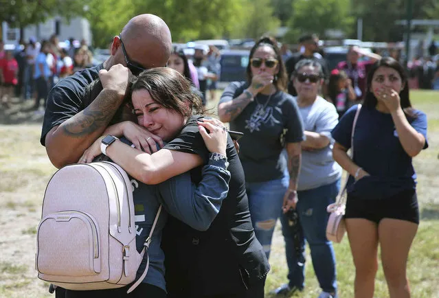 A family shares a tearful reunion following a chaotic scene outside of Thomas Jefferson High School in San Antonio, after the school went into lockdown on Tuesday, September 20, 2022. Alarmed parents laid siege to the Texas high school Tuesday after a classroom shooting report that ultimately proved to be false. (Photo by Kin Man Hui/The San Antonio Express-News via AP Photo)
