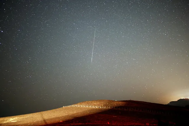 A meteor streaks across the sky in the early morning during the Perseid meteor shower in Ramon Crater near the town of Mitzpe Ramon, southern Israel, August 12, 2016. (Photo by Amir Cohen/Reuters)