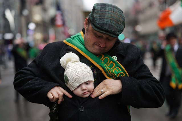 Patrick Victorson carries his son Chase in his jacket during the 264th annual St Patrick's Day parade on 5th Avenue in Manhattan in New York City, on March 17, 2025. (Photo by Mike Segar/Reuters)