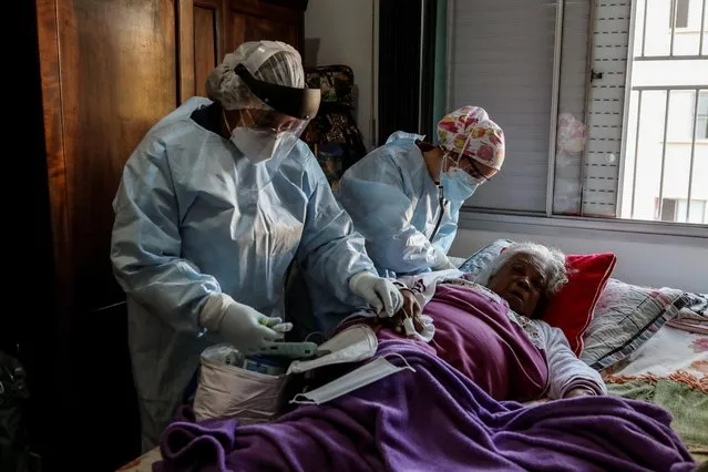 Emergency Rescue Service (SAMU) nurses Cristina Almeida and Belisa Marcelino attend to Maria Geralda da Silva, 84, who is experiencing breathing difficulty and others symptoms of the coronavirus disease (COVID-19) amid the outbreak, in Sao Paulo, Brazil, July 2, 2020. (Photo by Amanda Perobelli/Reuters)