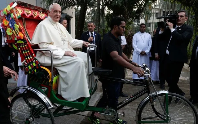 Pope Francis rides a traditional Bangladesh rickshaw as he arrives at an interfaith and ecumenical meeting for peace in the garden of the archbishop's residence, in Dhaka, Bangladesh, Friday, December 1, 2017. (Photo by Andrew Medichini/AP Photo)