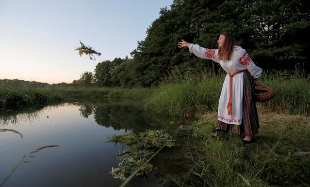 A woman throws a wreath to the river as she takes part in the Ivan Kupala festival in Belarusian state museum of folk architecture and rural lifestyle near the village Aziarco, Belarus, July 4, 2020. (Photo by Vasily Fedosenko/Reuters)
