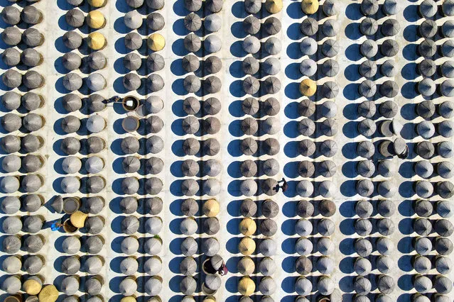 This aerial photo taken on October 19, 2022 shows workers producing soy sauce in Rugao in China's eastern Jiangsu province. (Photo by Reuters/China Stringer Network)