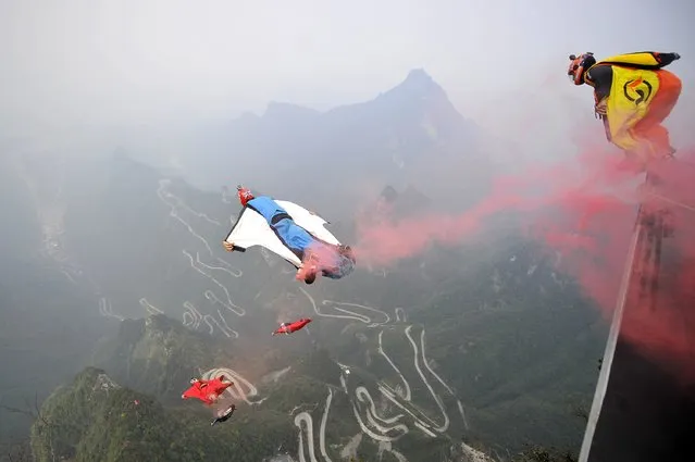Wingsuit flyer contestants jump off a mountain at Tianmen Mountain National Park in Zhangjiajie, Hunan province October 19, 2014. (Photo by Reuters/China Daily)