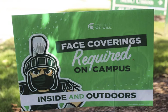 A sign outside the Michigan State University Student Union building alerts students to MSU's face covering rule on Friday, August 21, 2020. Students at Michigan universities are receiving emails from their schools welcoming them back for the fall, but a cloud of concern is hovering because of the coronavirus pandemic. To go online or to come in person has been the debate, but since Michigan State University announced Tuesday it will go online for the next semester, the debate is reaching a fever pitch. (Photo by Anna Nichols/AP Photo)