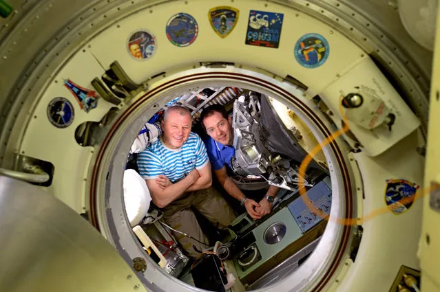 Russian cosmonaut Oleg Novitskiy, left, and French astronaut Thomas Pesquet sit in the Soyuz space capsule as they prepare for their return home from the space station, June 2017. (Photo by Jack Fischer/NASA)