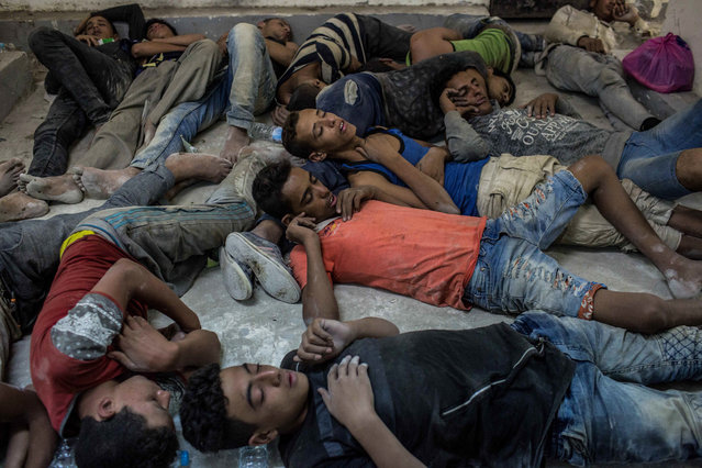 Young Egyptians detained at a police station sleep on the floor in Rosetta, Egypt, after rescued from a boat capsized off the Mediterranean coast near the Egyptian city of Alexandria, Wednesday, September 21, 2016. Egypt's official news agency MENA said the boat was carrying 600 people when it sank near the coast, some 180 kilometers (112 miles) north of the capital, Cairo. (Photo by Eman Helal/AP Photo)