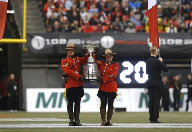 Royal Canadian Mounted Police officers hold the Grey Cup during ceremonies ahead of the start of the CFL's 102nd Grey Cup football championsionship between the Hamilton Tiger Cats and the Calgary Stampeders in Vancouver, British Columbia, November 30, 2014. (Photo by Todd Korol/Reuters)