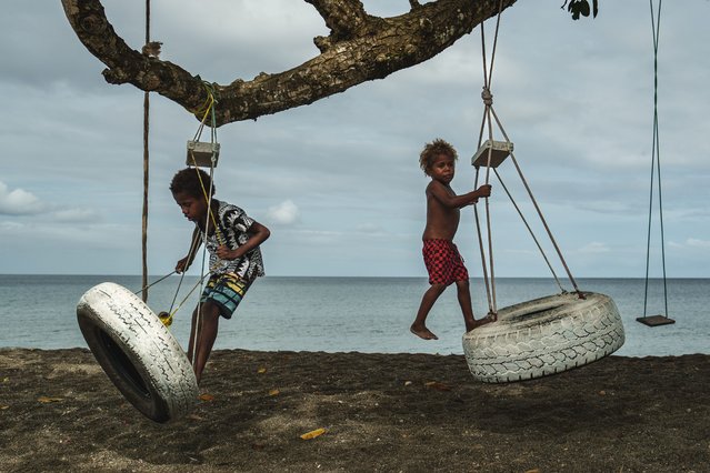 Children play on an uprooted tree along a beach in Mele, Vanuatu that was once lined with vegetation, now largely lost to storms, erosion and other environmental pressures on Saturday, July 19, 2025. (Photo by Annika Hammerschlag/AP Photo)